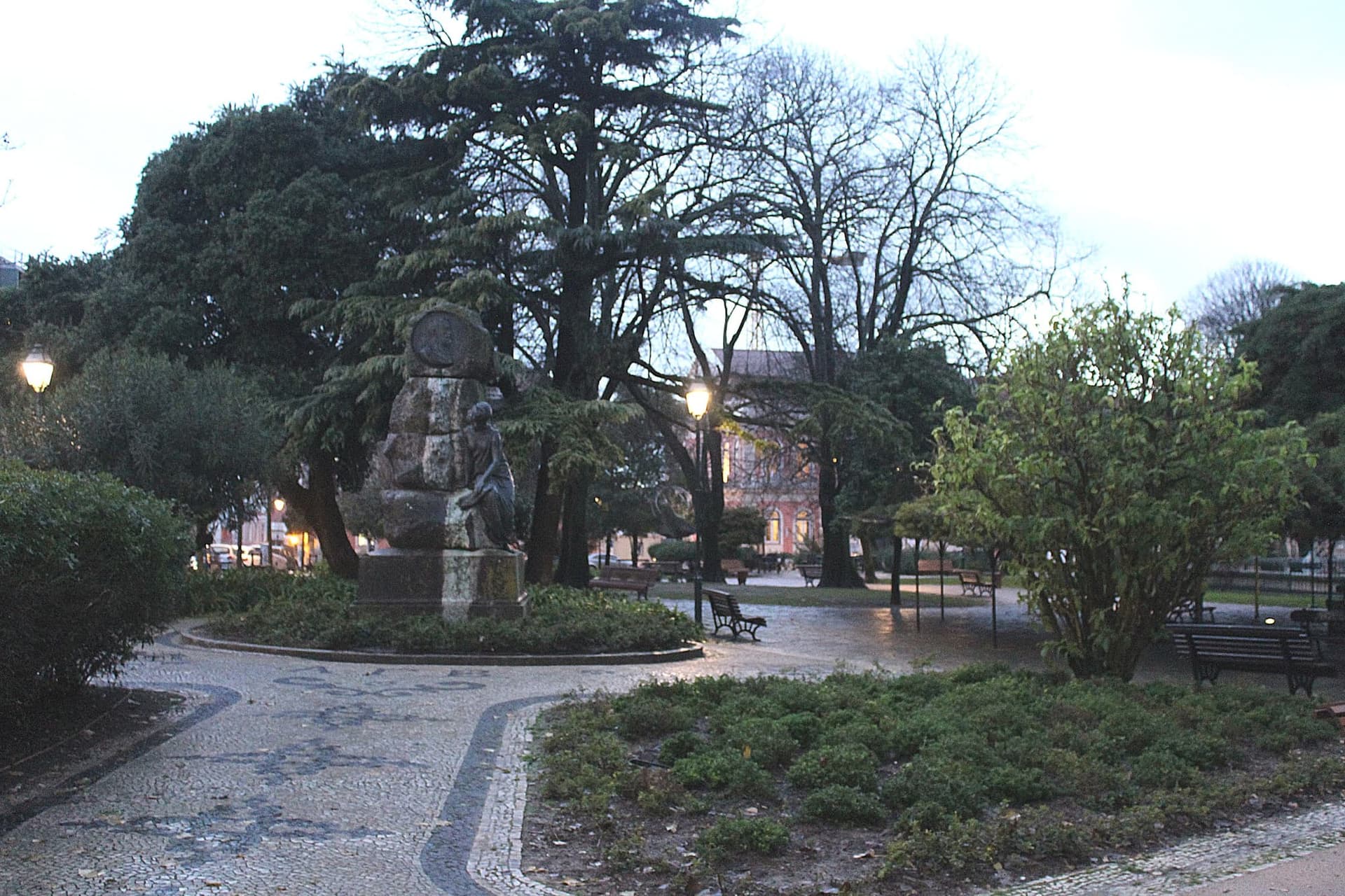 A shaded garden square in Príncipe Real with a huge spreading cedar held up on a metal frame.