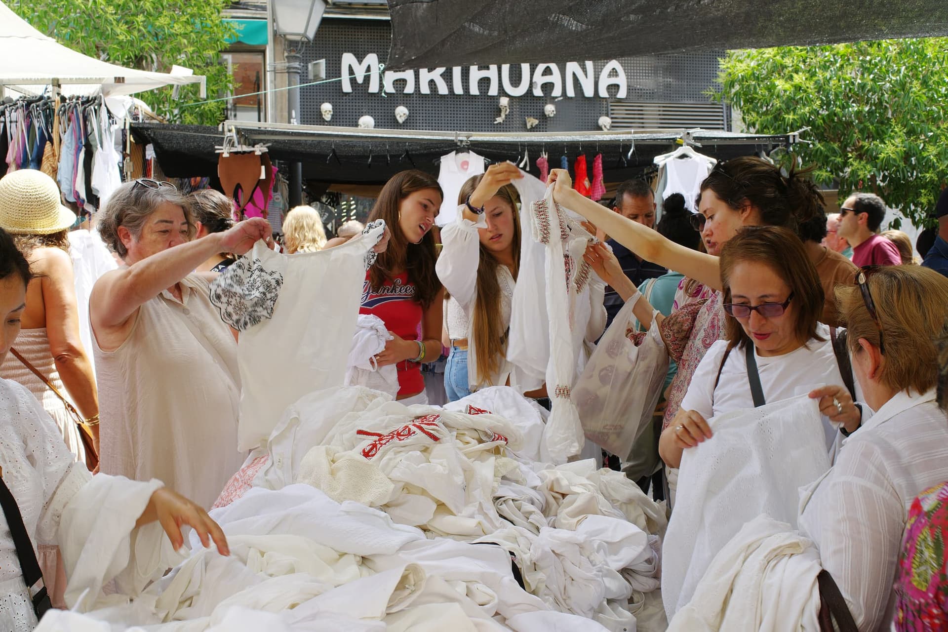 Crowds moving between stalls at El Rastro flea market on a Sunday morning in Madrid.