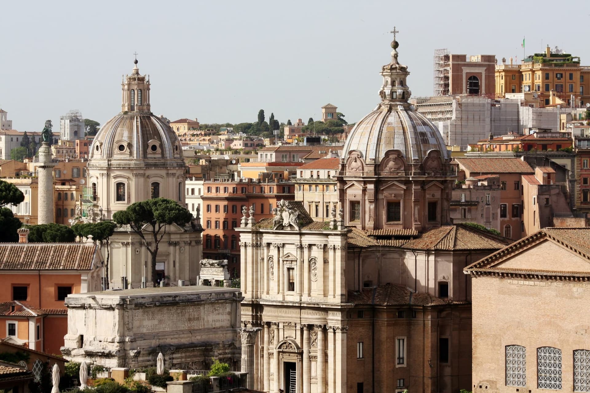 Rome's ochre rooftops running towards the horizon with church domes rising out of them.